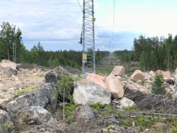 Kraftledningsgata som har alldeles kal och uppriven mark, stora stenbumlingar i förgrunden. Foto.